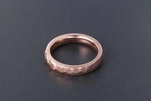 Close-up of rose gold plated titanium steel ring featuring a hand-hammered texture finish