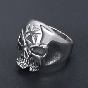 Men's punk skull ring in stainless steel with cross relief on dark textured background