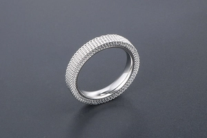 Macro shot of silver titanium steel mesh ring with intricate braided texture design