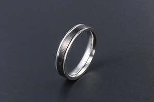 Détail d'une bague en acier titane avec chiffres romains sur bande centrale noire