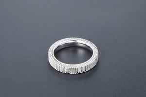 Detailed 45-degree angle of silver mesh texture ring in polished stainless steel