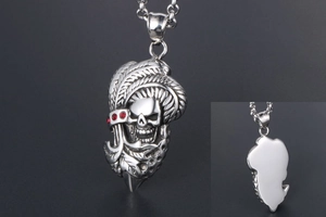 Détail du pendentif crâne punk avec motif plume et accents de pierres rouges