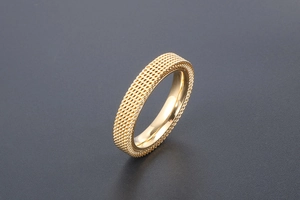 Macro detail of gold-plated titanium steel ring featuring mesh texture and polished inner