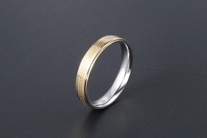 Detail view of titanium steel ring featuring gold-toned dotted texture and silver edges
