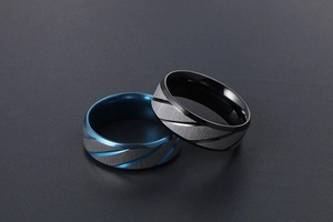 Macro shot of blue and black interior titanium rings with brushed metal surface