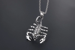 Close-up of a silver scorpion pendant with detailed box chain in punk style