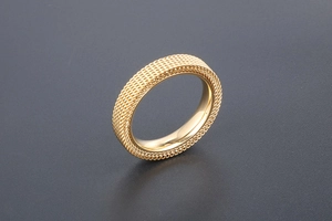 Detailed macro shot of a golden woven texture pattern on a titanium steel mesh ring