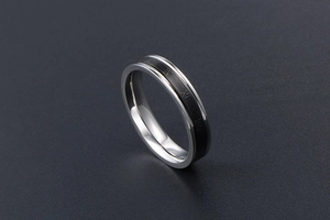 Détail macro de la bague en acier argenté avec bande noire et gravure de chiffres romains