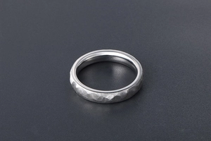 Macro shot of silver ring with hammered texture exterior and polished inner surface