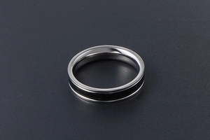 Détail d'une bague en acier titane argenté avec chiffres romains en émail noir