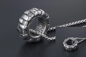 Vue détaillée du pendentif pneu en acier titane vieilli avec une chaîne à maillons