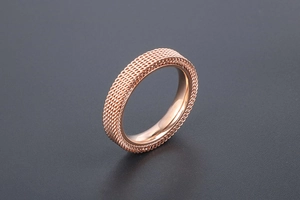 Macro shot of rose gold titanium steel ring with intricate woven mesh pattern