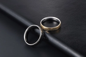Close-up of minimalist black and gold dotted titanium steel couple rings on leather