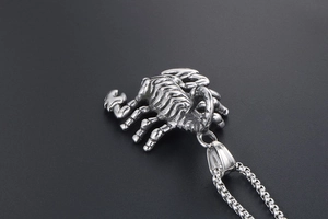 Detailed view of scorpion pendant showing skeletal textures on polished stainless steel