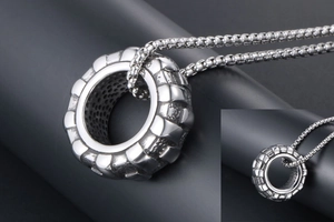 Détail macro d'un pendentif industriel à bande de pneu en acier inoxydable vieilli