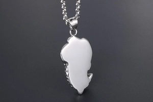 Gros plan détaillé du pendentif carte d'Afrique en acier inoxydable argenté avec textures