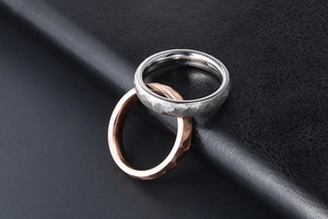 Detail of hammered texture on rose gold and silver stainless steel couple rings