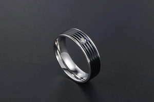 Gros plan d'une bague en acier titane rayé avec une pierre de zircon blanc incrustée