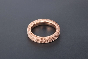Detail of rose gold mesh titanium steel ring featuring a polished inner surface
