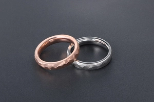 Close-up of rose gold and silver hammered titanium steel rings with textured facets