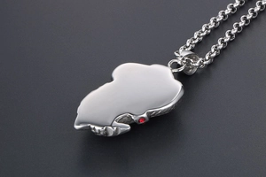 Détail du pendentif carte d'Afrique en argent avec surface polie et petite pierre rouge