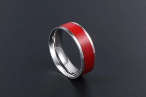 Macro shot of silver titanium steel ring with vibrant red enamel inlay and polished finish