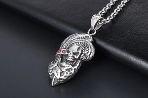 Détail macro du pendentif crâne et aile gothique avec strass rouges sur cuir noir