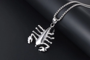 Macro shot of silver scorpion pendant with detailed metallic texture and linked chain