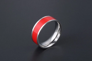 Close-up of polished stainless steel ring with vibrant red enamel inlay detail