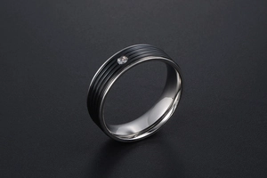 Vue détaillée d'une bague en acier titane avec rayures noires et zircon central serti