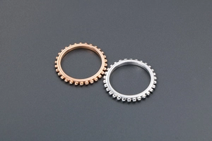 Detailansicht von kugelrandigen Titanstahlringen in Roségold und Silber-Finish