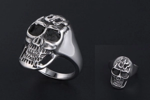 Macro detail of men's titanium skull ring with engraved flame motifs and vintage finish