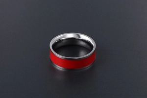 Detail of titanium steel ring featuring a vibrant red enamel inlay and polished finish