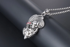 Gros plan du pendentif crâne punk avec strass rouges et détails de plumes indiennes
