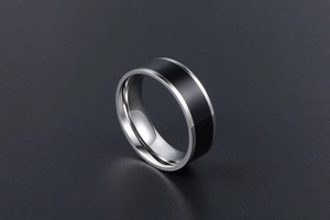 Detail of polished stainless steel ring featuring a sleek black enamel center inlay