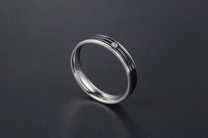 Gros plan sur une bague en titane argenté avec doubles rainures noires et un diamant incrusté