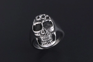 Macro shot of silver stainless steel skull ring with intricate flame head details