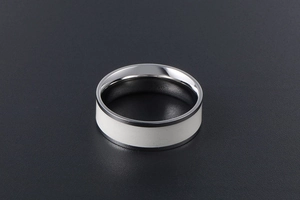 Detailed view of titanium steel ring with wide white enamel inlay and silver metallic finish
