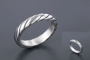 Dettaglio di un anello vintage argento con design a corda intrecciata in acciaio lucido