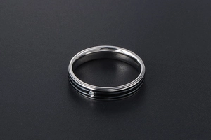 Détail d'une bague en acier titane argenté avec doubles rayures noires et zircon central