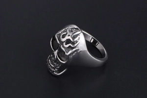 Detailed close-up of a punk flame skull ring in polished silver titanium steel