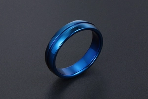 Vue détaillée d'une bague en acier bleu poli avec un design discret à rainure centrale