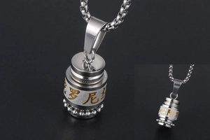 Macro view of silver cylinder pendant necklace with golden Buddhist scripture and bead chain