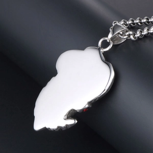 Pendentif punk en acier titane poli avec motif crâne et feuille orné d'une pierre rouge