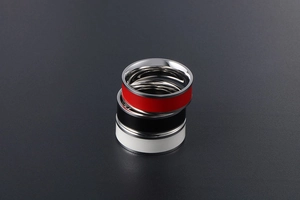Close-up of three minimalist titanium steel rings with red, black, and white enamel inlay