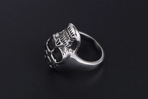 Detailed view of punk style skull ring with raised relief texture in silver metal