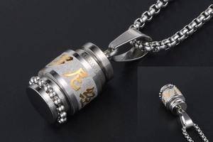 Macro detail of stainless steel rotating pendant necklace with gold engraved scriptures