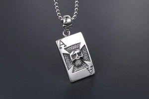 Vue détaillée du collier gothique en acier avec tête de mort 3D et pendentif As de Pique