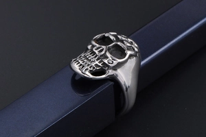 Detailed close-up of a punk style silver skull ring with realistic bone carvings