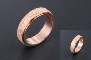 Macro shot of rose gold spinner ring with frosted finish and rotatable sandblasted band